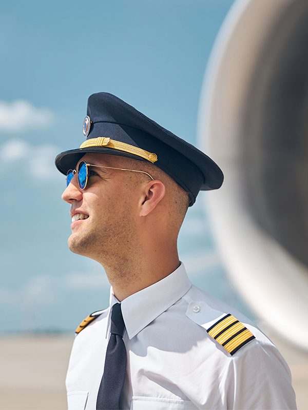 cheerful-pilot-in-sunglasses-standing-outdoors-in-BX8GZXEaa.jpg